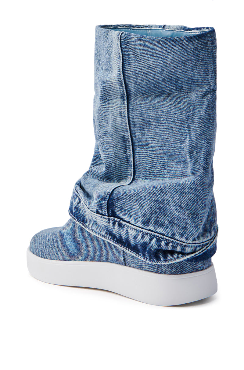 The AZALEA WANG KIMIKA DENIM BOOTIE features a slouchy upper and flat white sole in a denim-textured, faded blue look, merging casual style with a unique design. It's shown from the back and side with a mid-calf shaft for added flair.