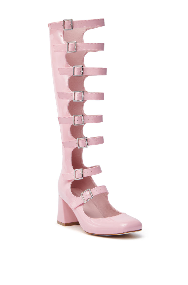 The AZALEA WANG LAIMA PINK PATENT CHUNKY BUCKLE BOOT is a glossy pink knee-high gladiator-style boot with chunky silver buckles on multiple straps, a rounded toe, and a chunky heel.