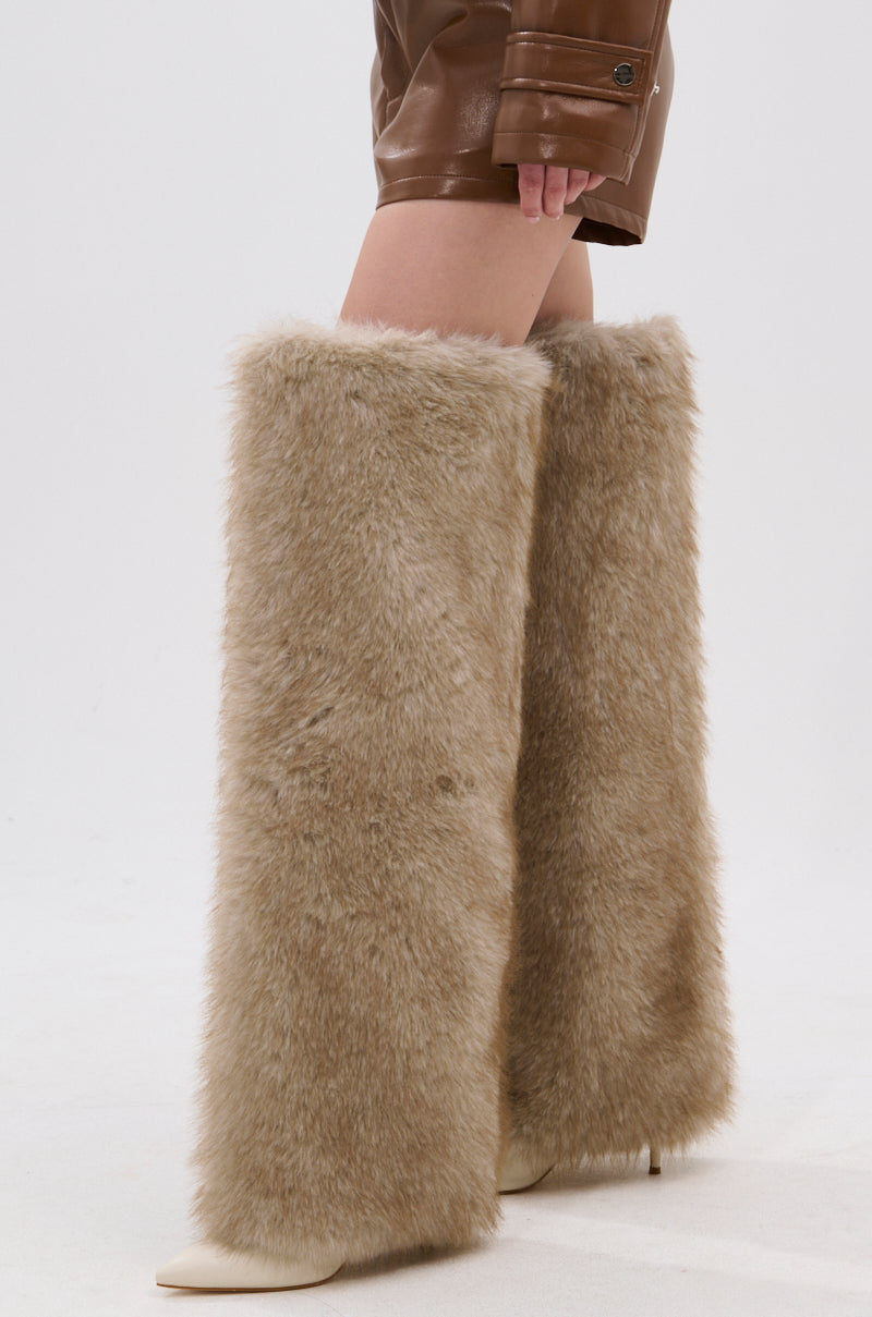 A person models the AZALEA WANG LAGANN BONE THIGH HIGH FUR LUXE BOOT, styled with brown leather shorts, against a plain white background.