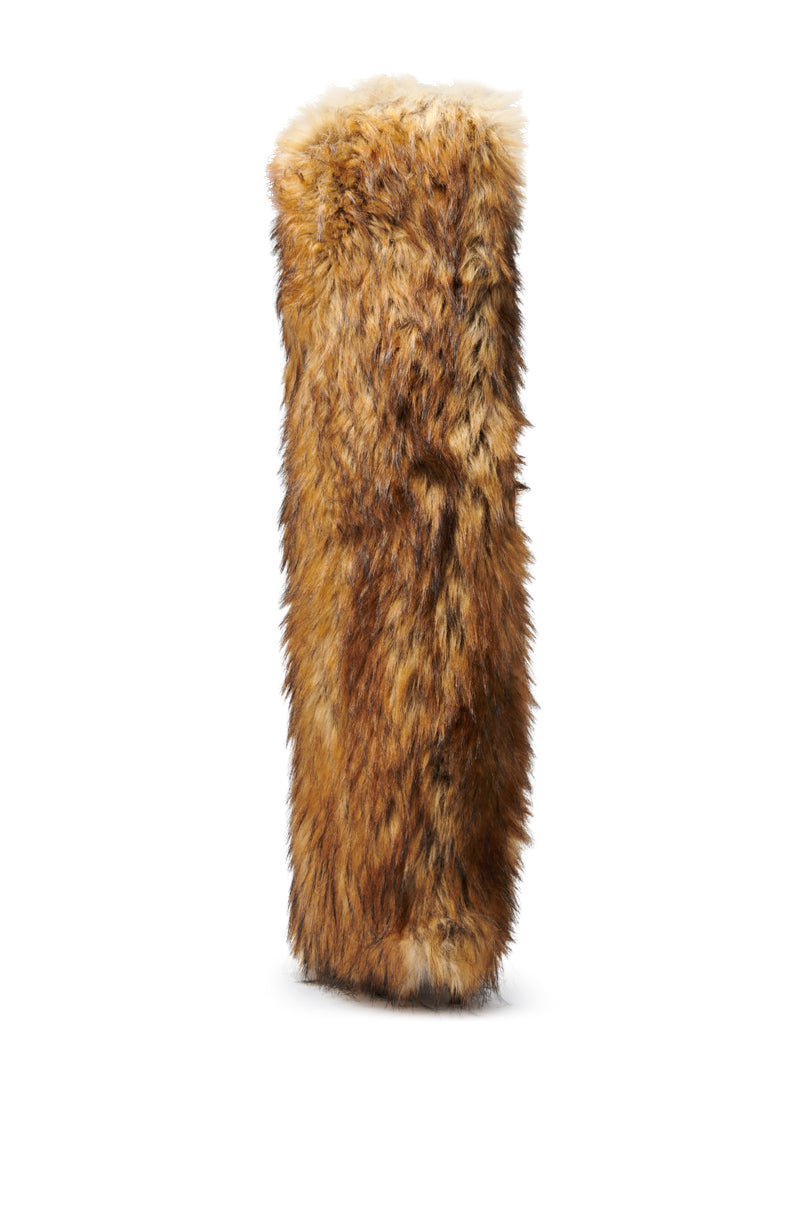 The AZALEA WANG LANGDON BROWN THIGH-HIGH FUR LUXE BOOT features thick, brown and tan fur with a fluffy texture, and a softer, lighter cuff at the top. The boot stands upright against a plain white background.