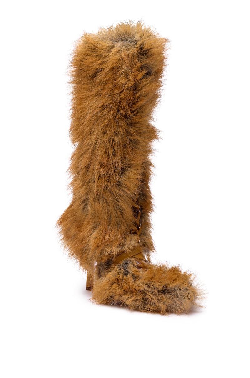 The AZALEA WANG LOURDANNE TAN FUR LACE UP STILETTO BOOT, a knee-high stiletto with shaggy light brown faux fur, pointed toe, and high heel, is shown against a plain white background.