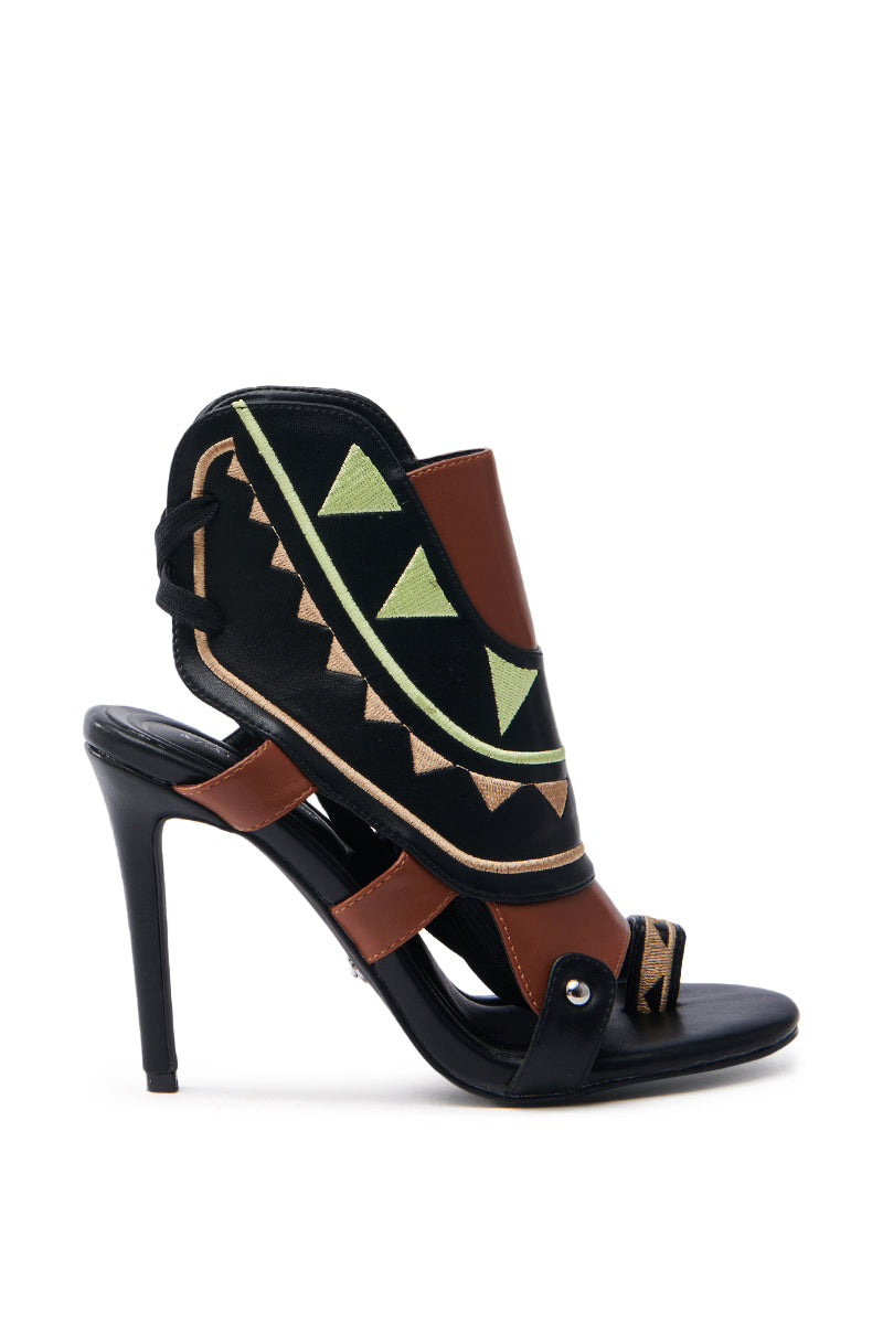 The AZALEA WANG MERAKI BLACK AND BONE SANDAL is a high-heeled vegan leather design featuring a black base, an ankle cuff with brown and olive green geometric patterns for a chic color block look, and slender front straps with black and brown detailing.