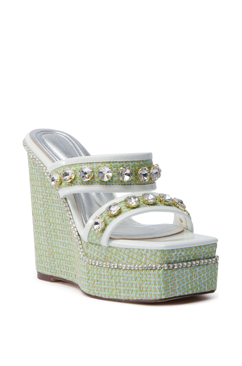 The AZALEA WANG NIOMA GREEN EMBELLISHED WEDGE SANDAL boasts a textured platform sole, chunky wedge heel, and two rhinestone-adorned straps. Its green and blue woven pattern with a shiny insole make it a striking wardrobe addition.