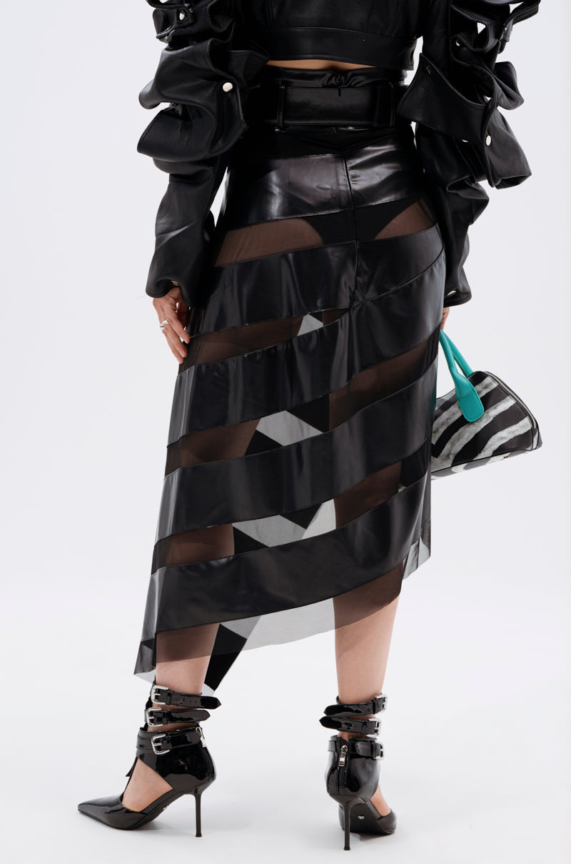 A person in a black leather jacket, pointed buckle heels, and the SOMETHING DIFFERENT MESH MIDI SKIRT WITH FAUX LEATHER holds a turquoise and black handbag, standing against a plain white background.