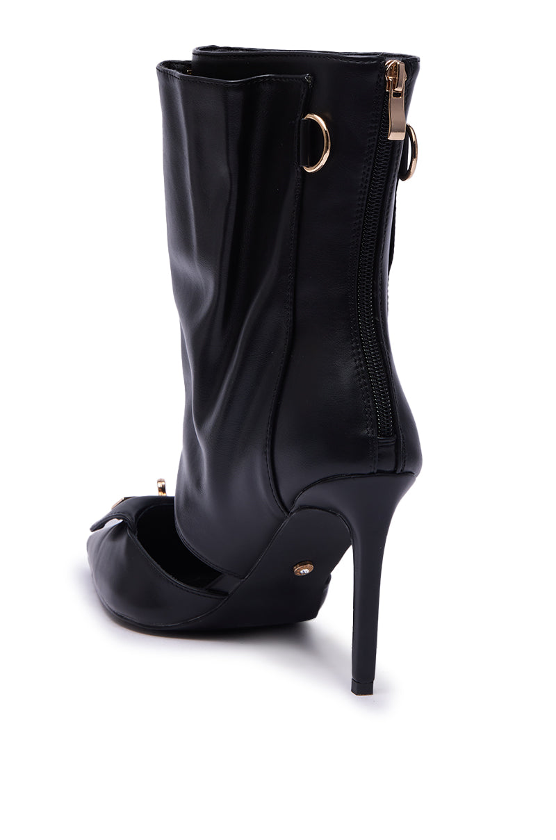 The AZALEA WANG SARVESH BLACK CUTOUT STILETO BOOTIE features a high heel, peep toe, gold back zipper, and gold hardware accents, shown from the rear on a white background.