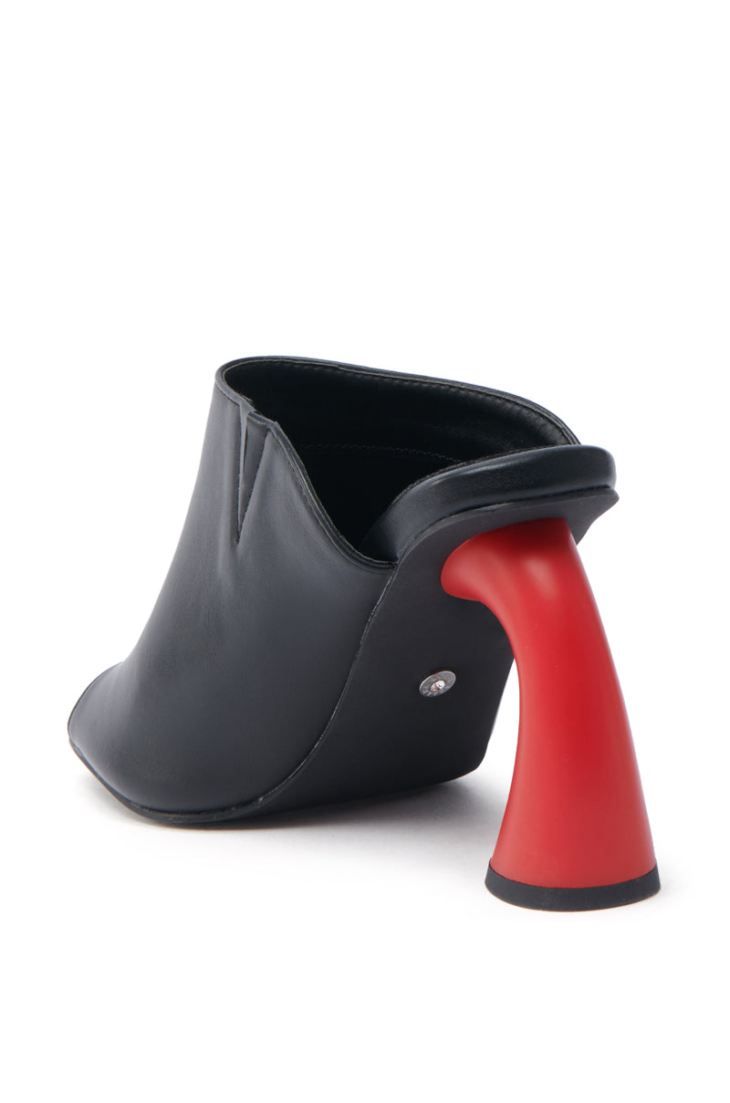 The AZALEA WANG SIDLE BLACK SLIP ON MULE SANDAL WITH RED HEEL features a chic minimalist design, a curved red heel reminiscent of modern art, and high-quality faux leather. Its smooth contours and open back give it a stylishly contemporary look.