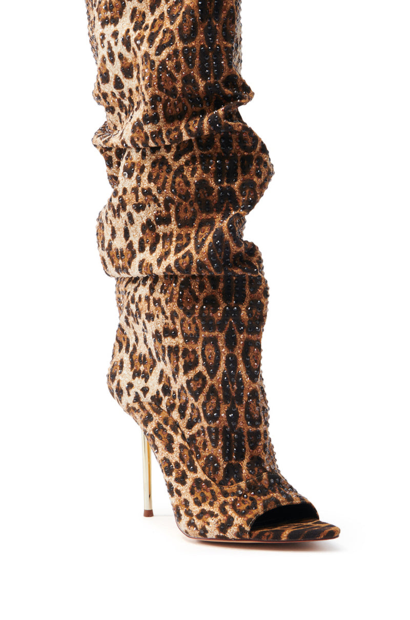 Introducing the AZALEA WANG SPHYNX LEOPARD OPEN TOE BOOT: a knee-high faux suede boot with leopard print and metallic studs. Features a pointed toe, slim stiletto heel, and gathered soft material around the ankle for a slouchy effect.
