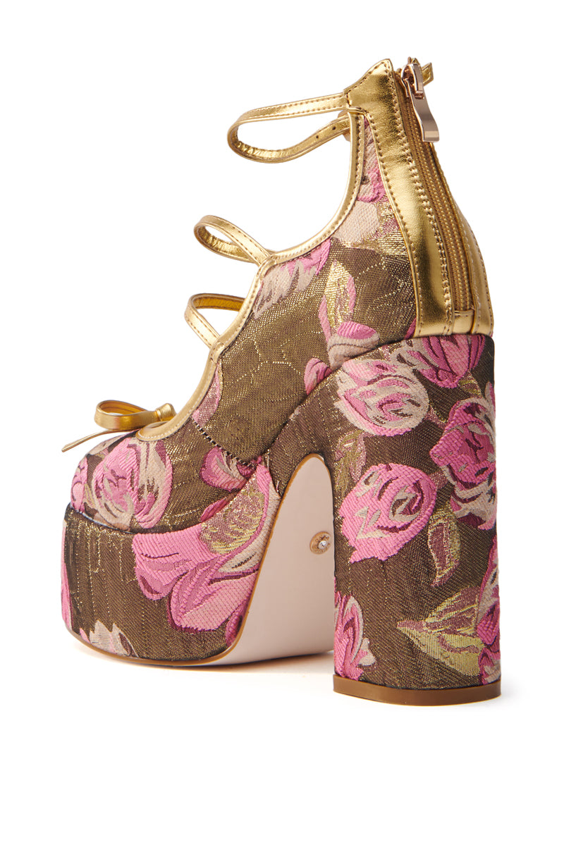 The AZALEA WANG SPROUT GOLD BROCADE PUMP is a high-heeled platform shoe with pink roses on a brown floral pattern, metallic gold straps, a back zipper, and a mega-chunky heel for a bold design.