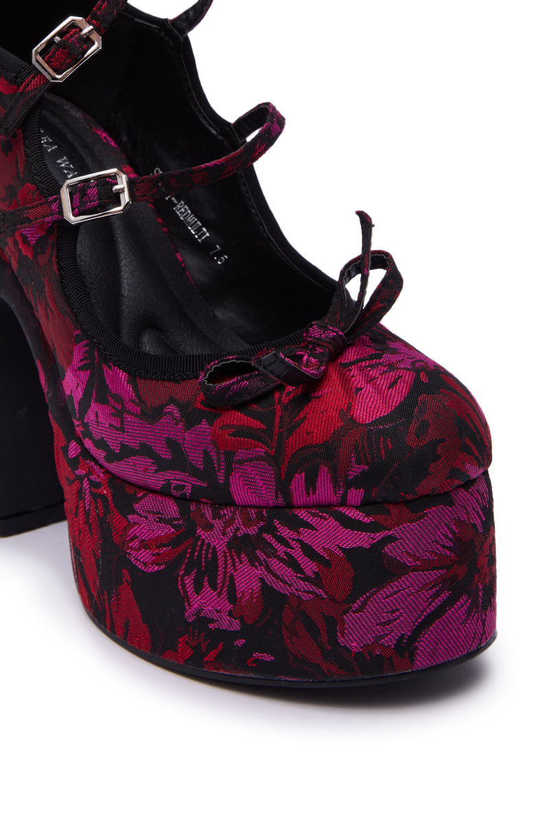 The AZALEA WANG SPROUT Red Multi Floral Brocade Mary Jane Platform Pump features vibrant pink and red flowers on black, a thick chunky heel, black straps, and small buckle details.