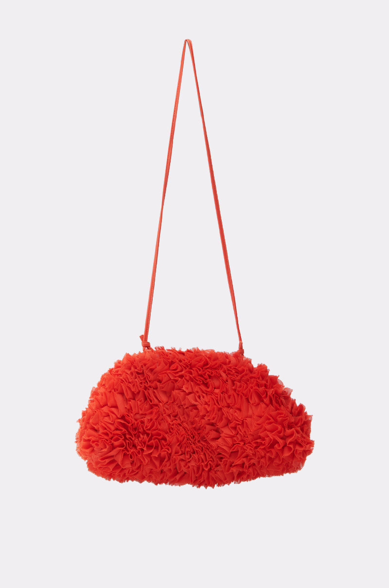 The RUFFLED UP CLUTCH, in vibrant red with a textured surface and a slim matching shoulder strap, is shown against a simple light backdrop.