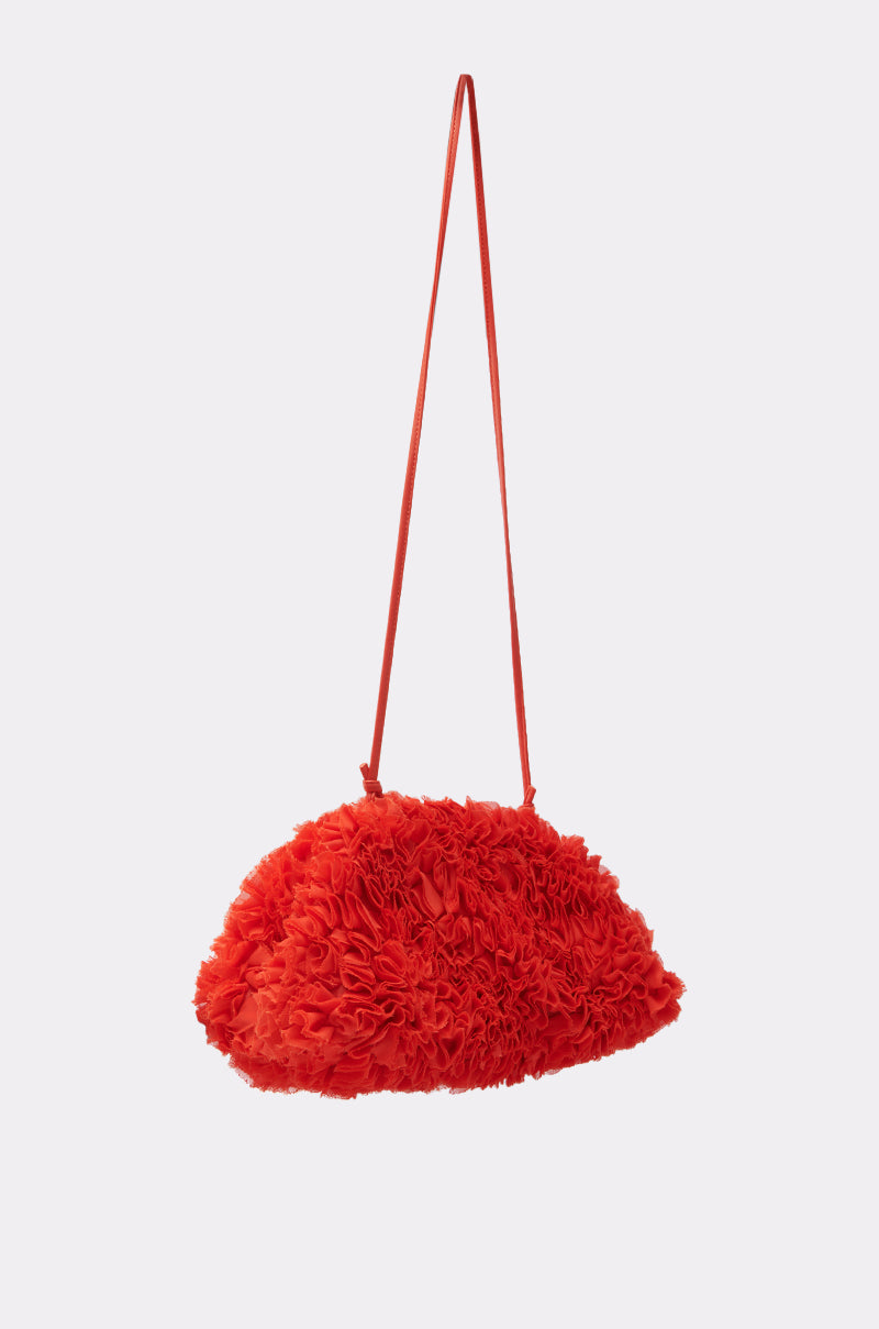 The RUFFLED UP CLUTCH stands out in bright red with an oversized, textured ruffled design and a detachable shoulder strap, displayed against a plain light background.