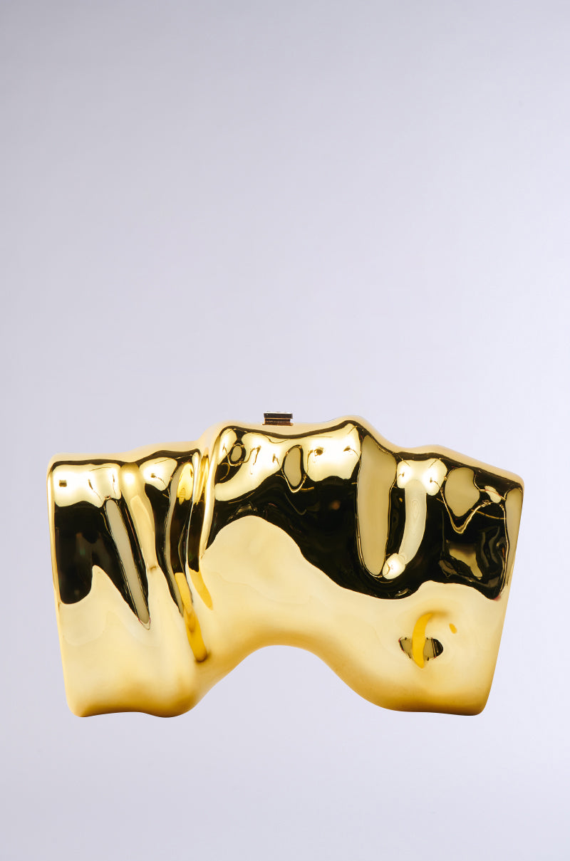 The FOR THE TIMES CLUTCH features a shiny, abstract design with an uneven, sculptural surface and is displayed against a plain light gray background—a true statement piece.