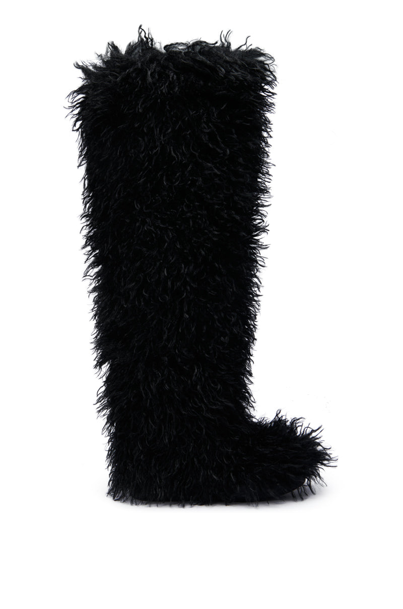 The AZALEA WANG TEMPLETON Black Poodle Fur Over The Knee Boot is showcased against a plain white background, featuring a tall, shaggy design with a poodle fur texture. This faux fur boot has a rounded toe and an over-the-knee length, presenting a plush and cozy look.