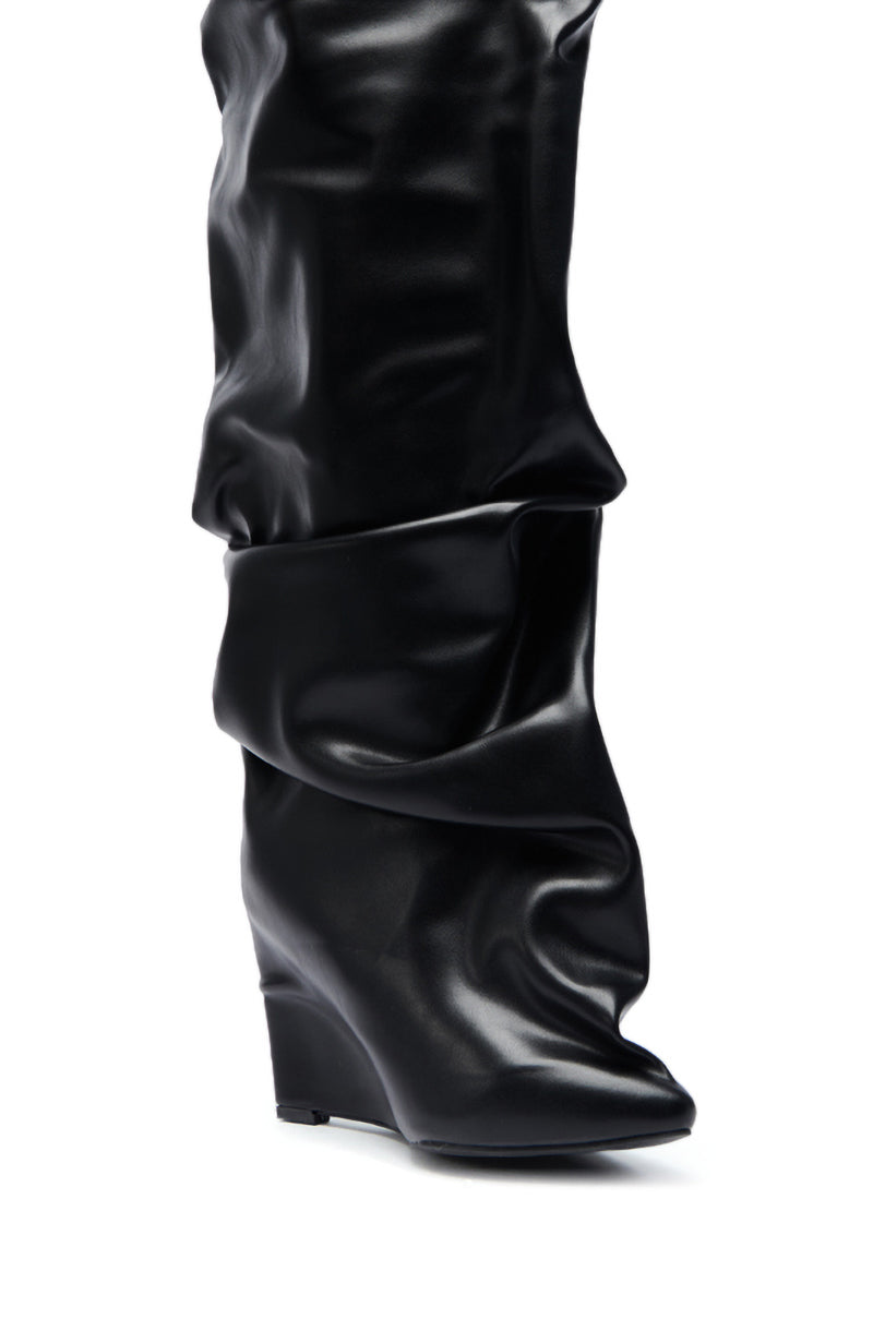 The AZALEA WANG TEUILA BLACK RUCHED WEDGE BOOT showcases shiny faux leather, a slouchy knee-high ruched shaft, pointed toe, and hidden wedge heel in black, displayed on a white background.