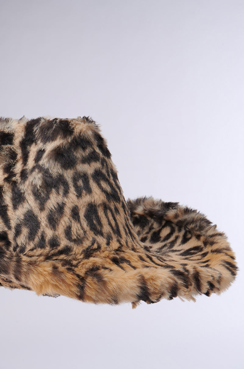 Brimming with a distinctive Western style, the CHECK ME OUT FAUX FUR COWBOY HAT boasts a bold design with its soft leopard-print faux fur. Displayed against a simple light backdrop, this hat's wide brim and textured surface capture attention effortlessly.