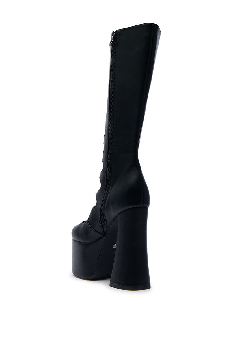 The AZALEA WANG TOMLIN BLACK BOOT, crafted in black faux leather with a chunky high platform heel, showcases a sleek side zipper. Photographed from the rear against a plain white background, its mid-calf design exudes both daring and elegance.