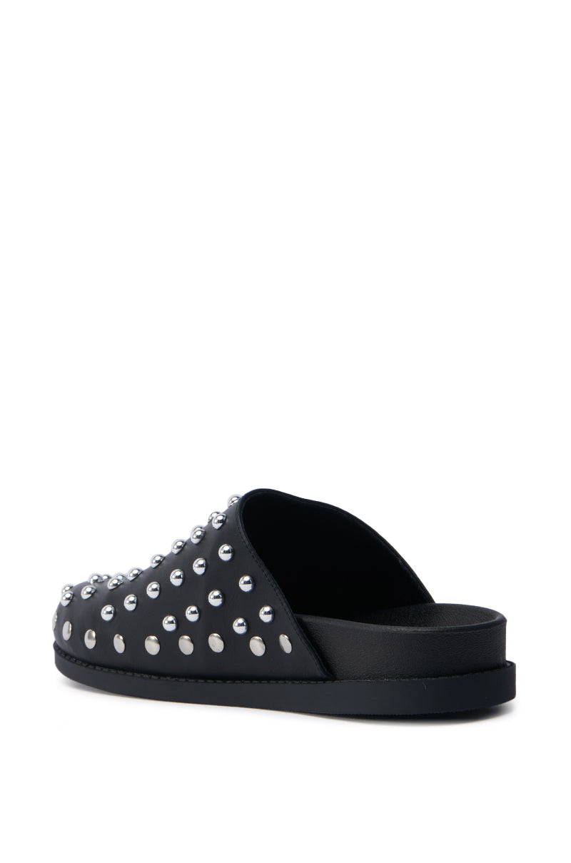 The AZALEA WANG TRAVERSE BLACK CLOG is a black slide sandal made of faux leather with a flat sole and multiple silver studs on the upper. It is displayed on a white background in side and partial top views.