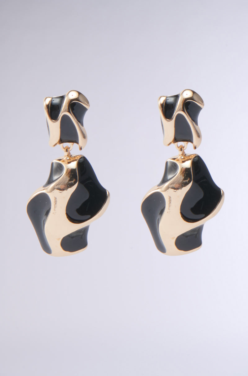 The FOR THE VIBES EARRING features a gold and black abstract dangle design with glossy black details and a sculptural, modern look, shown against a plain light gray background.