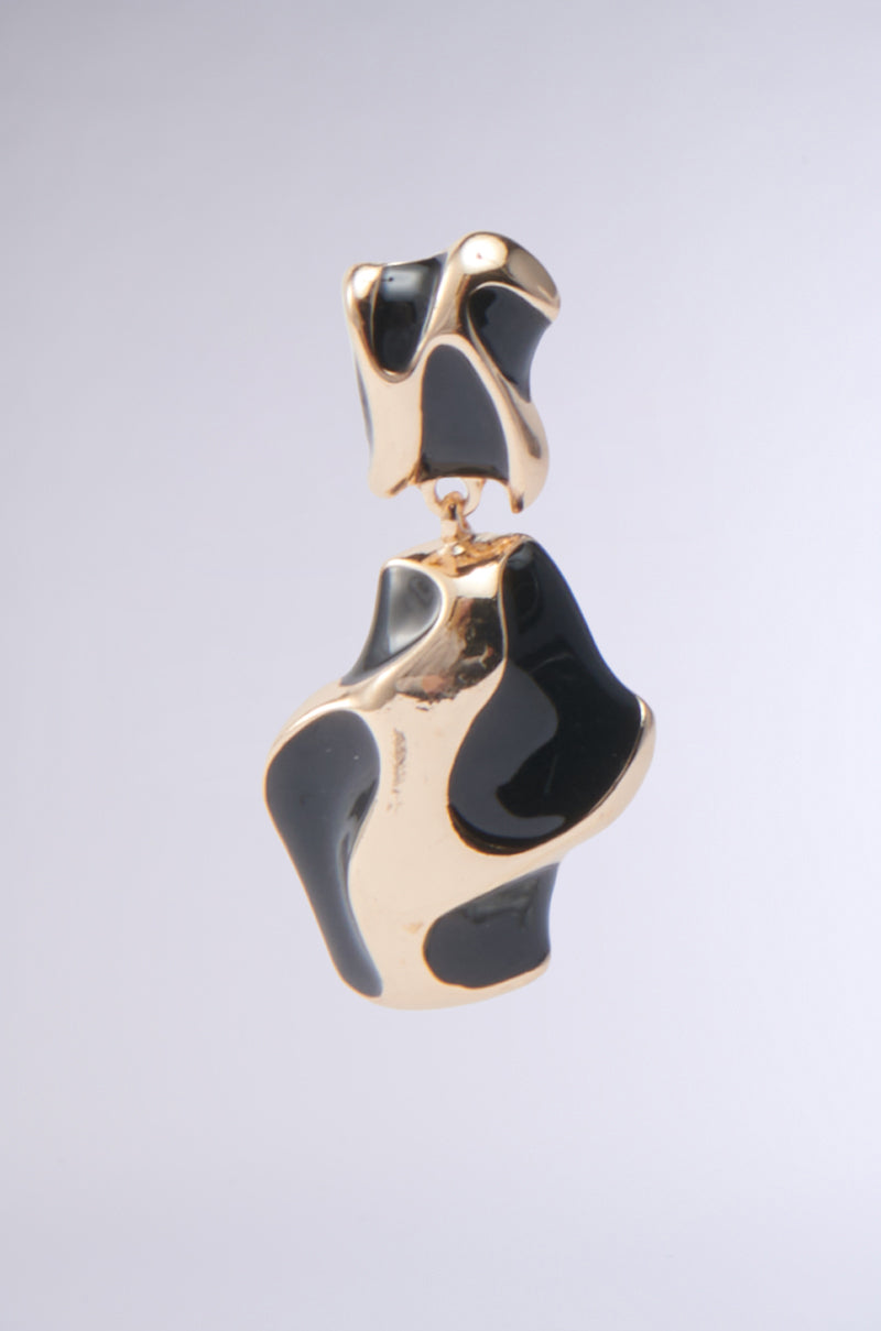 The FOR THE VIBES EARRING features an abstract gold and black design with a shiny, wavy surface, shown against a plain light gray background.