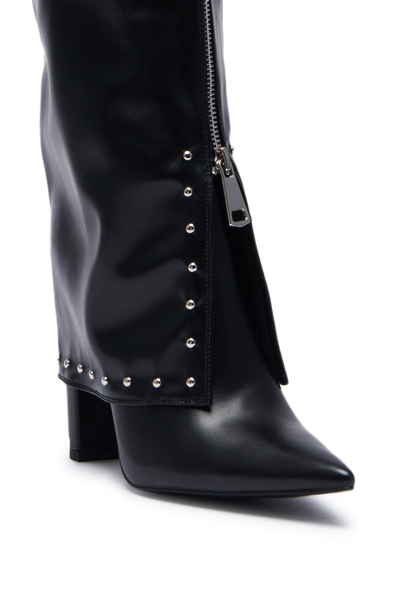 Close-up of the AZALEA WANG VEEVEE BLACK STILETTO BOOT, showcasing the sleek black faux leather design with a silver zipper partially open and aligned with small round silver studs along the side. The boot features a pointed toe and a chunky heel.