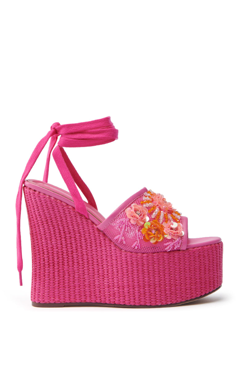 The AZALEA WANG VONDA Pink Wedge Sandal showcases a vibrant pink hue, woven base, and high platform sole with floral embroidery. It also features adjustable ankle ties and an open-toe design.