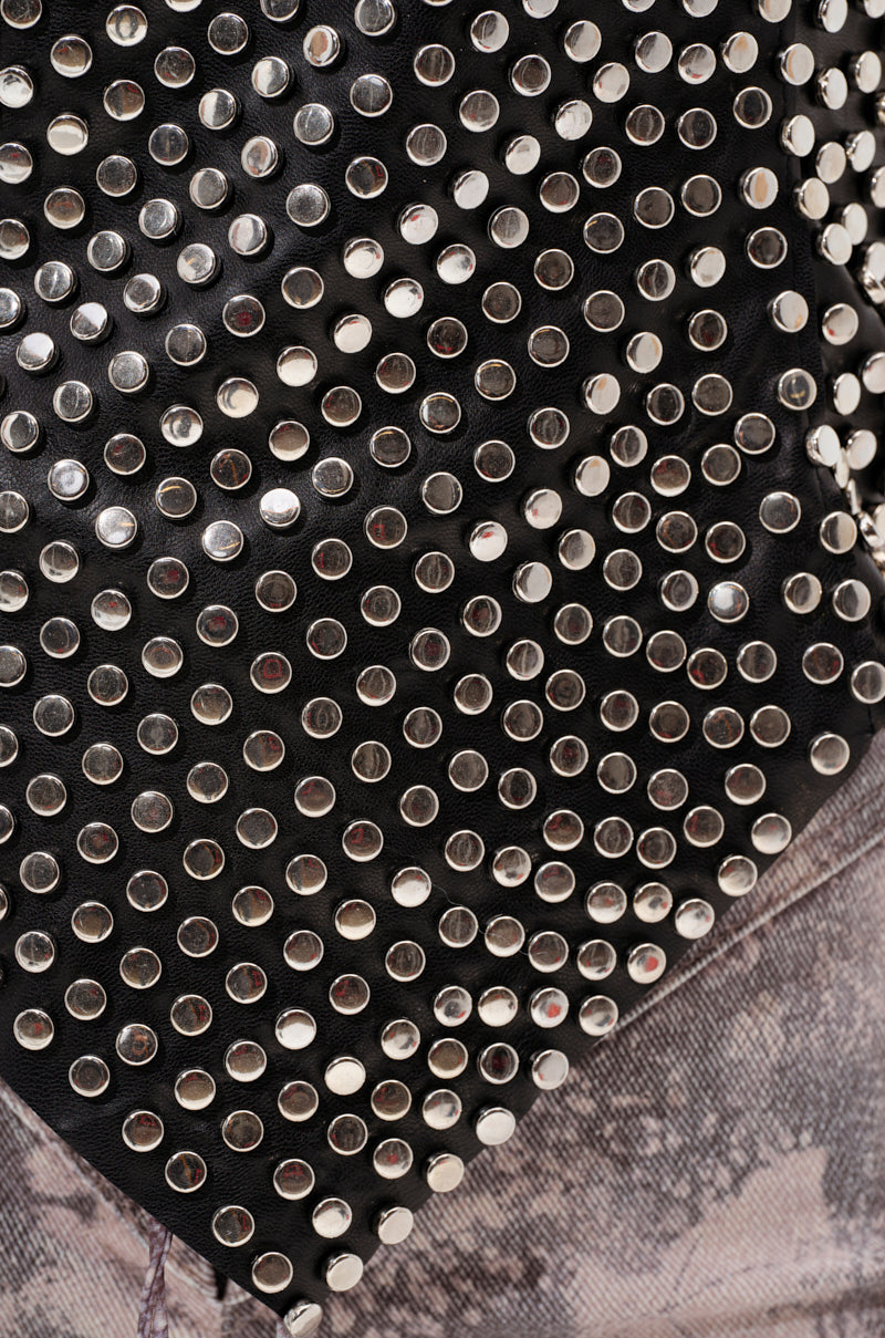 Close-up of the LETS GET FUNKY BEADED TOP, featuring faux leather adorned with rows of round silver studs and a hint of faded, light-wash denim fabric at the bottom.