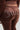 A person wearing the SOLID RIB WAIST VELOUR PANT with rhinestone embellishments spelling "Juicy" on the back. The image captures the lower back and upper thighs, highlighting the Juicy Couture branding detail. This Y2K-inspired look epitomizes early 2000s fashion nostalgia.