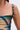 Close-up of a person's shoulder wearing the IN A MOOD PRINTED MINI DRESS with black straps and sparkling silver buckles. The dress’s bold abstract print contrasts with the plain, light-colored background.