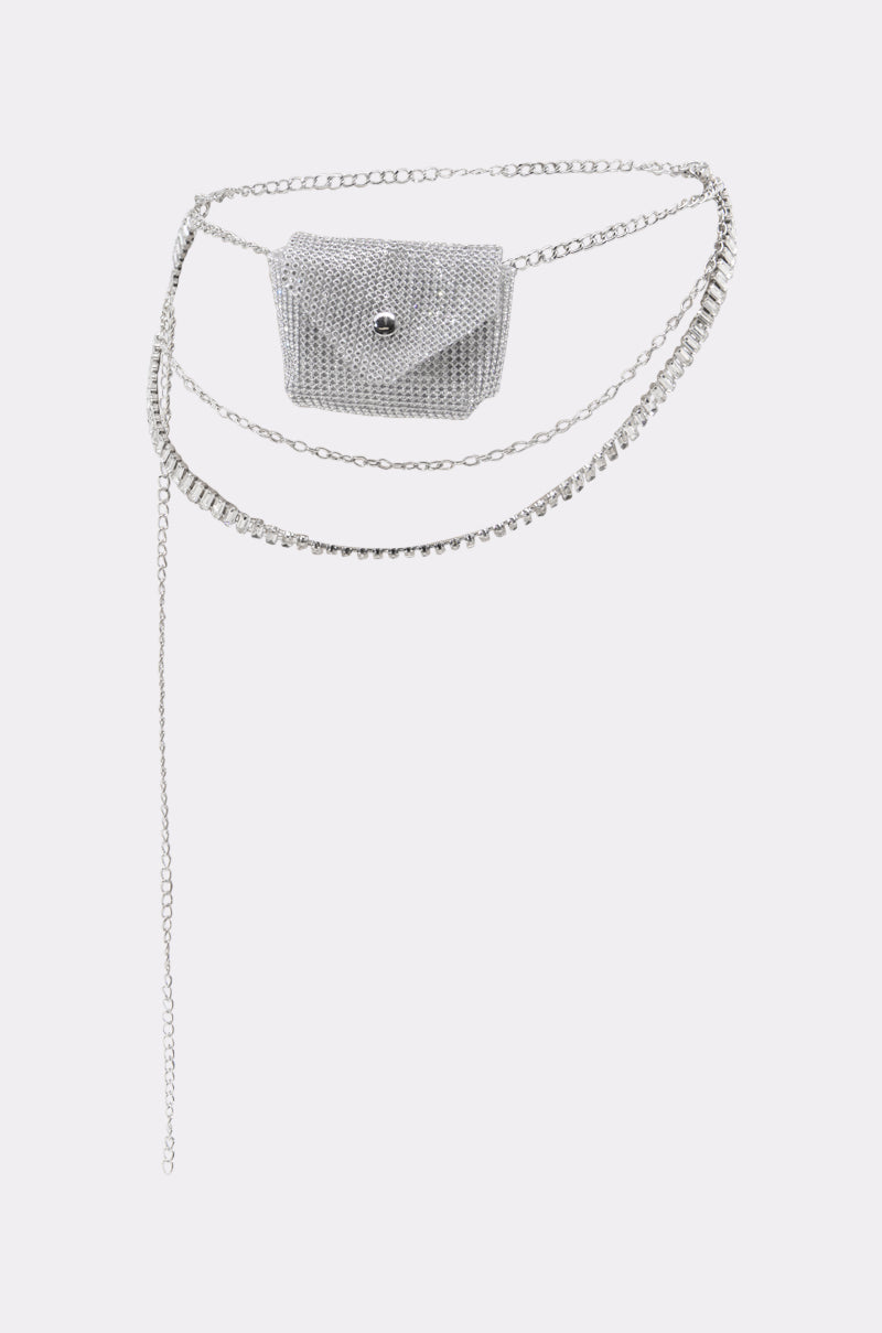 The IN MY BAG BLING CHAIN BELT features a silver chain with layered accents and an attached rhinestone mini bag, perfect for festival fashion. Displayed on a plain white background.