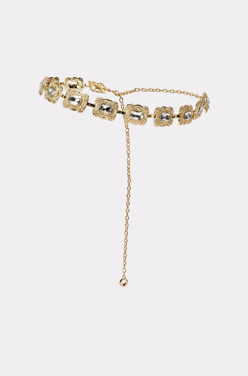 The GODDESS VIBES CHAIN BELT is a vintage-glam gold chain belt featuring clear rectangular gemstones in ornate settings, finished with a fine gold chain and extended drop chain ending in a loop. 2