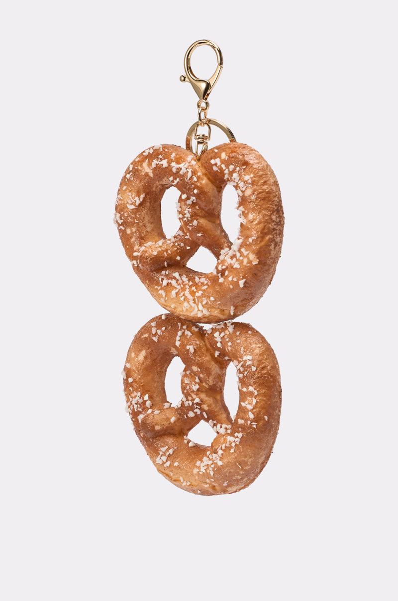 The NEEDED SOME SALT OVERSIZED KEYCHAIN features two salted pretzels stacked vertically on a gold clasp, making a charming novelty accessory against a plain white background. 2
