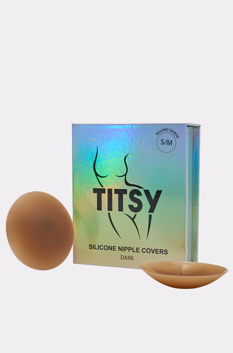 A holographic box labeled "TITSY THIN EDGE SILICONE NIPPIE COVER" shows two brown adhesive covers—one flat, one curved—for seamless, discreet coverage under any outfit.
