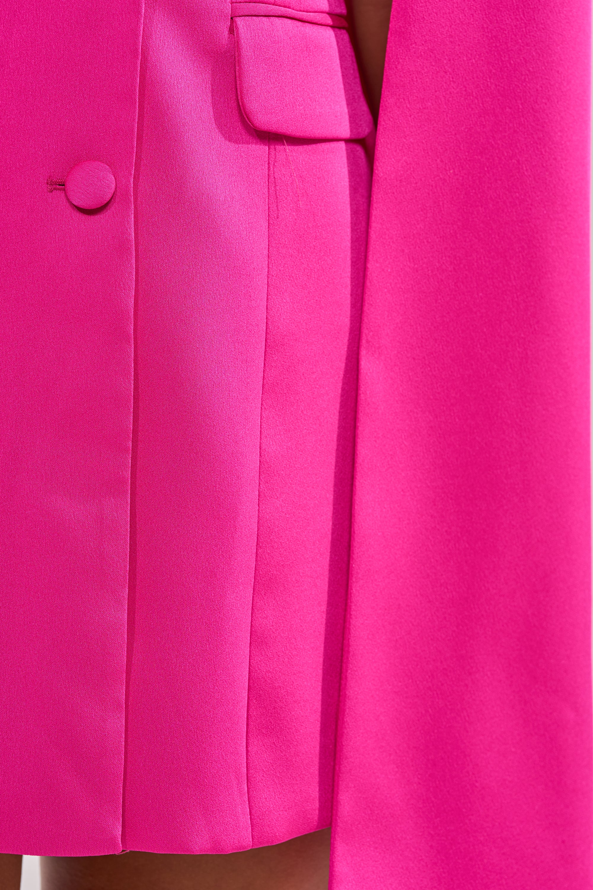 Close-up of the A LA MODE MINI BLAZER DRESS IN PINK, showing its button, flap pocket, clean tailored seams, and vibrant pink fabric for a standout look. 8