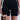 A person wears TITSY TUMMY TUCK SHORTS IN BLACK. The black high-waisted shorts have seamless hems and short legs, paired with a black bra in an inset image. Its high-rise fit provides sleek support against a plain white background.