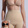 A person in high-waisted TAN TITSY TUMMY TUCK shorts and a nude bra is shown from the neck down. An inset reveals the same individual before wearing the shorts, in a black bra with noticeable midriff differences highlighted by their high-rise fit.