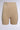 The TITSY TUMMY TUCK SHORTS in tan feature a high-rise fit and seamless hems for smooth body contouring, displayed against a plain, light gray background.