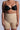 A person in a black bra and TITSY TUMMY TUCK SHORTS IN TAN with seamless hems stands against a light background, showing small arm tattoos and red-painted fingernails.