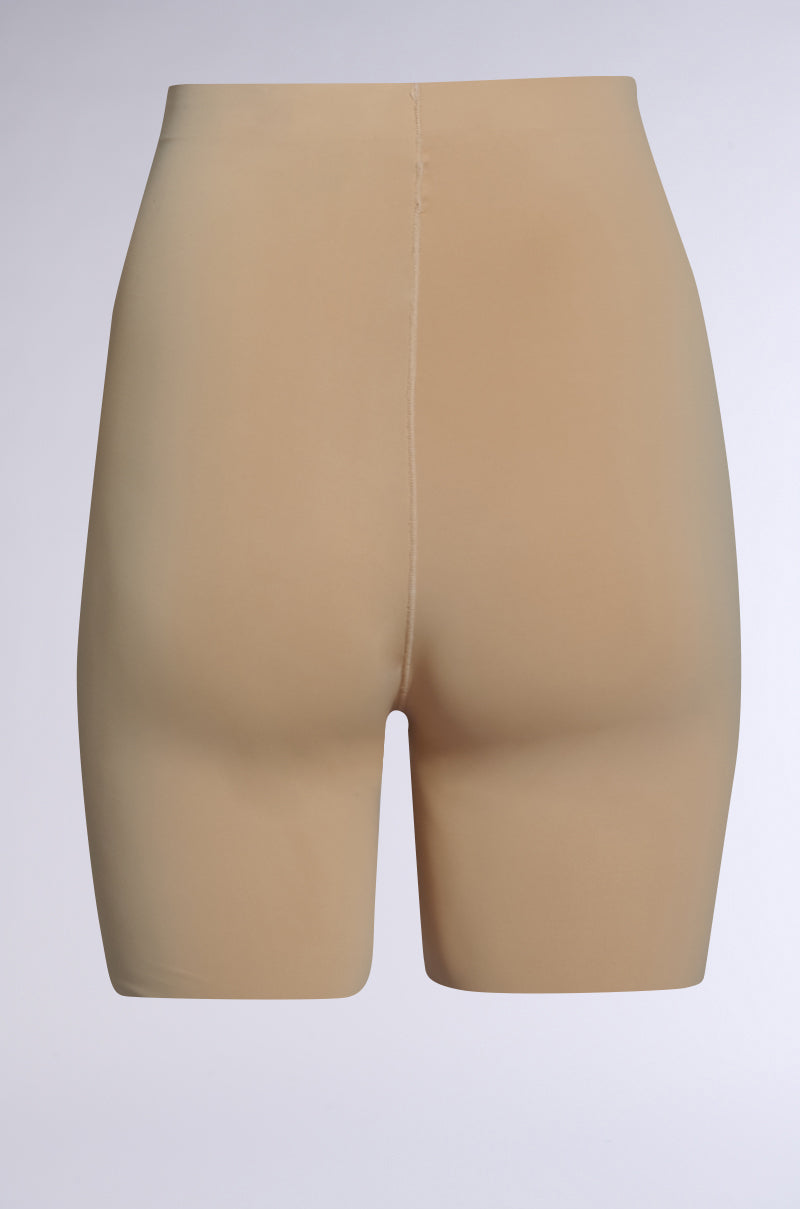 The TITSY TUMMY TUCK SHORTS IN TAN are high-waisted, seamless shapewear designed to provide smooth support and a slimming effect. The stretchy fabric ensures comfort, while the seamless hems enhance its sleek appearance against a neutral background. 3