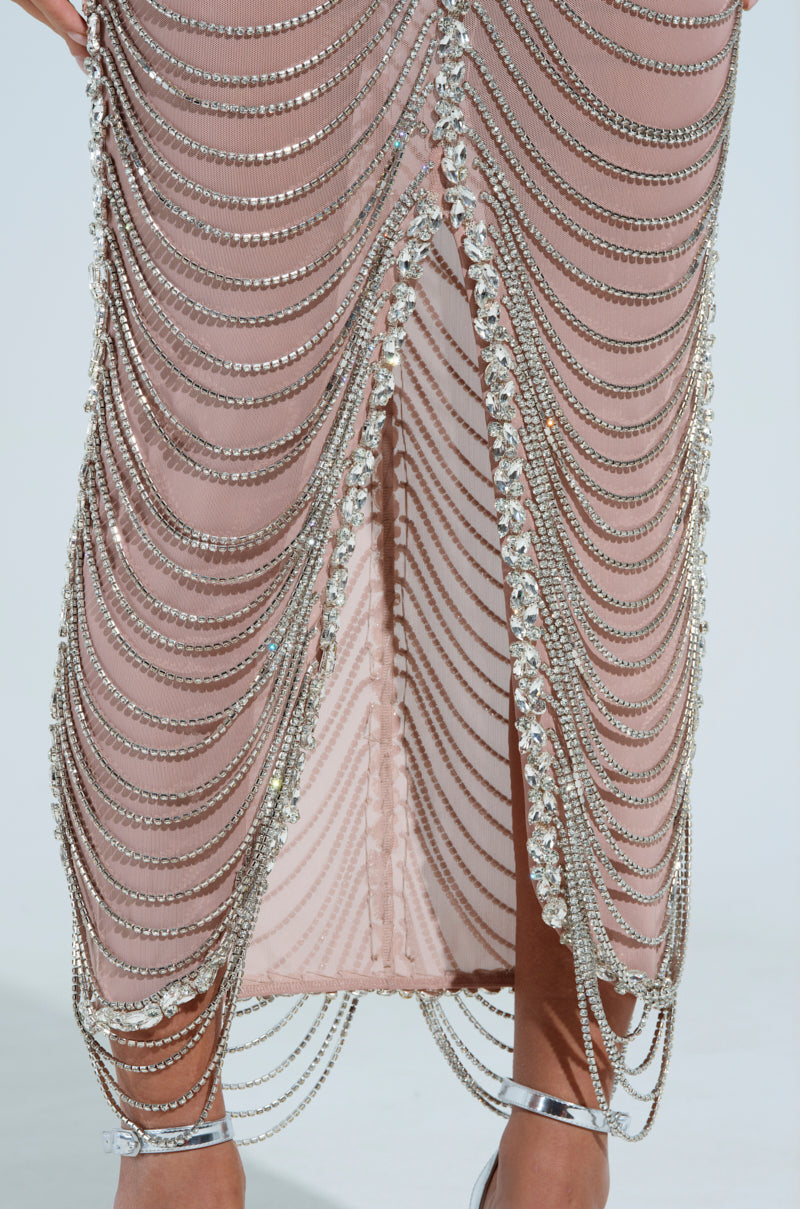 Introducing the DOMINATE CHAIN MAXI DRESS: a pink, semi-sheer mesh dress with layered silver chains and rhinestone links. It has a central slit revealing part of the legs and pairs perfectly with silver high-heeled sandals.