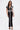 A woman poses against a white background in the LUCKY NUMBER 7 MAXI DRESS—a black mesh varsity-style dress with short sleeves, white trim, a front zipper, and 