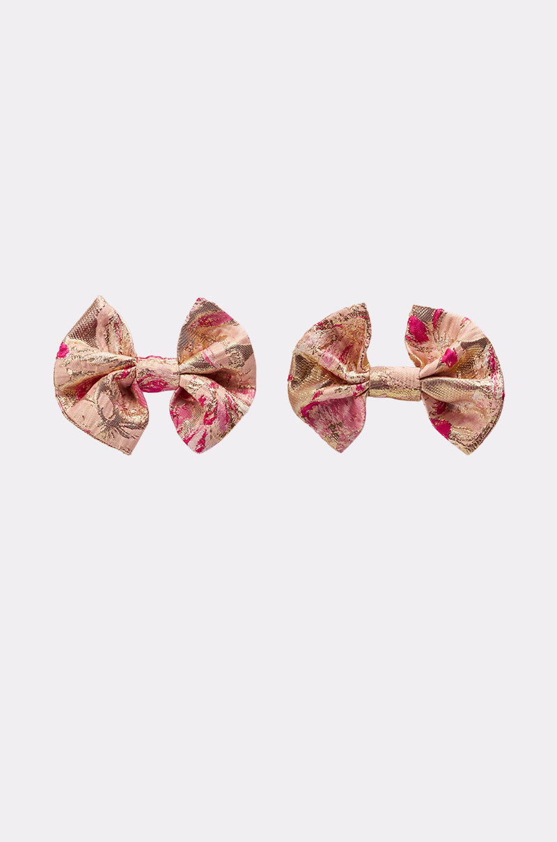 Two REALLY ME BOW EARRINGS with a metallic gold base and pink floral brocade patterns are displayed side by side on a plain white background. 2