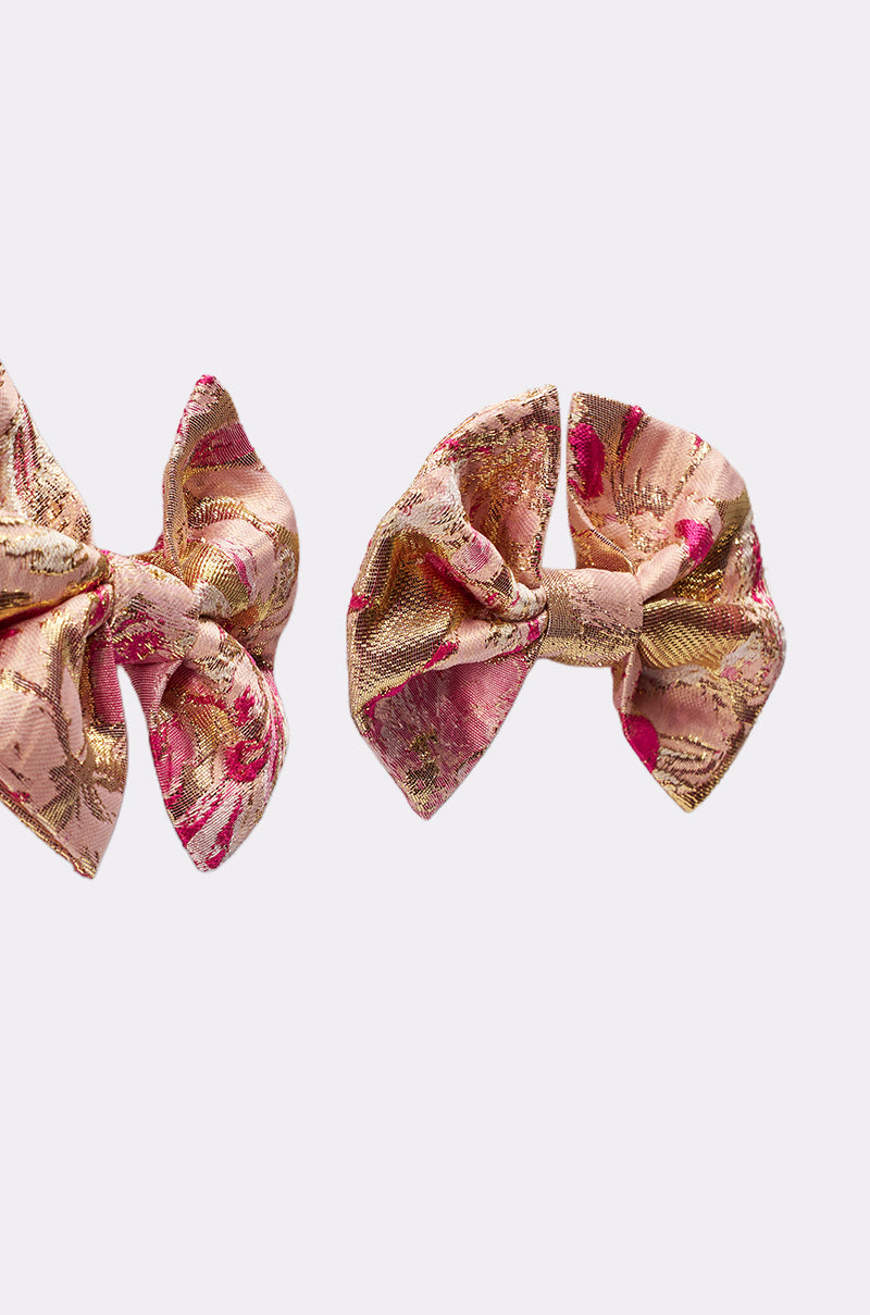 Two REALLY ME BOW EARRINGS, featuring a pink and gold brocade floral design, are displayed on a plain white background. 4
