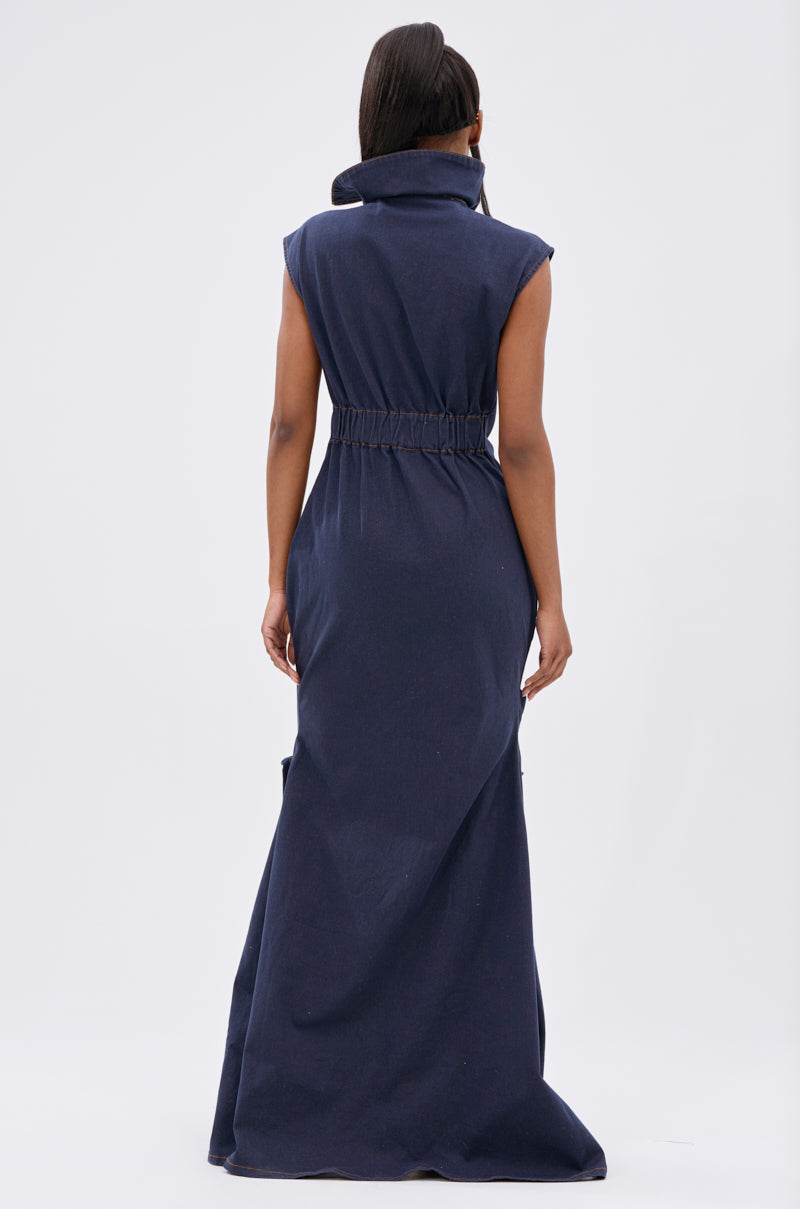 A woman with straight hair stands facing away against a light background, wearing the DONT MESS WITH ME COLLARED DENIM MAXI DRESS featuring a high collar and gathered waist.