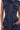 Someone wears the DONT MESS WITH ME COLLARED DENIM MAXI DRESS, a sleeveless dark wash style with prominent copper zippers, utility chest and hip pockets, bold topstitching, and an asymmetrical front zip; one hand rests in a hip pocket.
