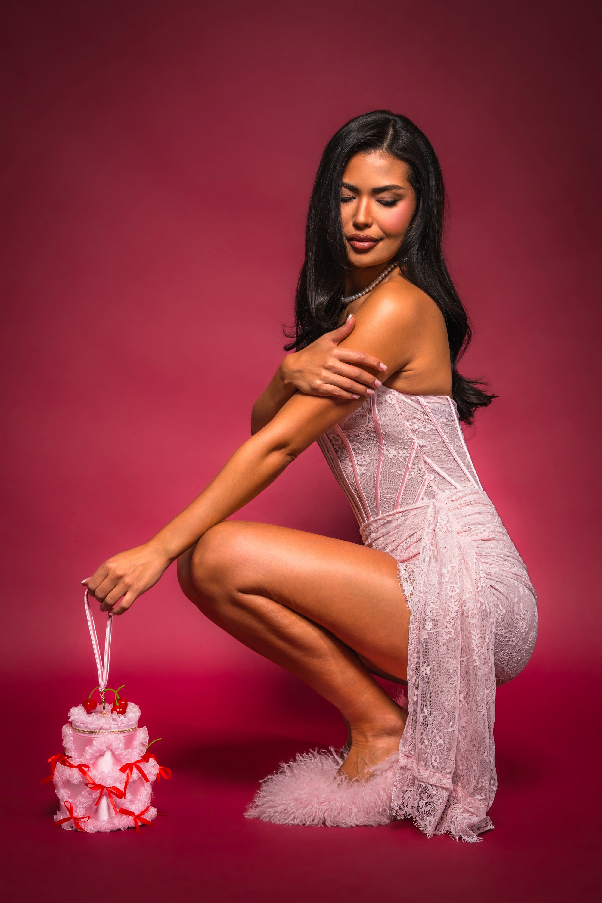 A woman in the WRAP ME IN LACE PINK MINI DRESS holding a cake. 2