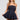 A woman in the Felt Cute Poplin Mini Dress in blue pinstripe holds the hem of her short, flared skirt. She accessorizes with large hoop earrings, a pearl necklace, and white thigh-high stockings. Her blonde hair is loose as she stands against a plain gray background.