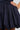 A close-up image showcases the FELT CUTE POPLIN MINI DRESS IN BLUE PINSTRIPE. The fabric is gathered at the waist to create a flared effect, with a hand resting casually on the hip.
