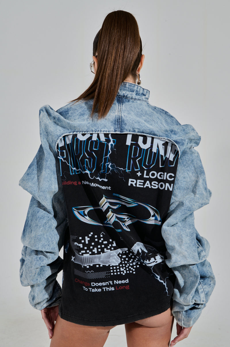A person with their long hair tied up showcases the oversized SPOIL ME DENIM BOLERO, featuring intricate graphic designs and bold text on the back. The mix of patterns makes an artistic statement against a simple gray background.