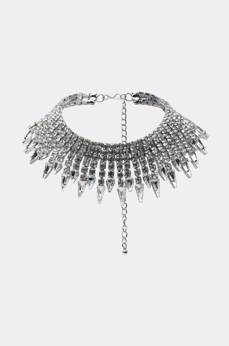 The MY THORNS BLING NECKLACE is a silver choker with multiple rows of sparkling rhinestones and dangling crystal-like spikes, finished with an adjustable chain clasp at the back.