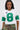 A woman wears the WINNERS ONLY RHINESTONE SHORT SLEEVE TEE, styled with camouflage lace-up pants, long straight hair, and large hoop earrings for a sporty yet stylish look.